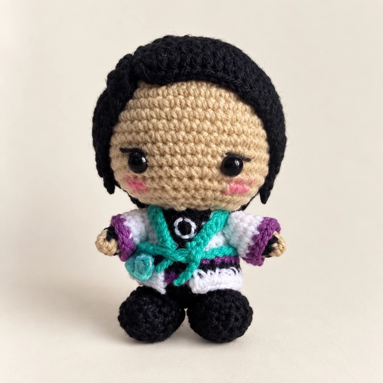 Black-haired Sage crochet doll in a white and teal outfit with black boots