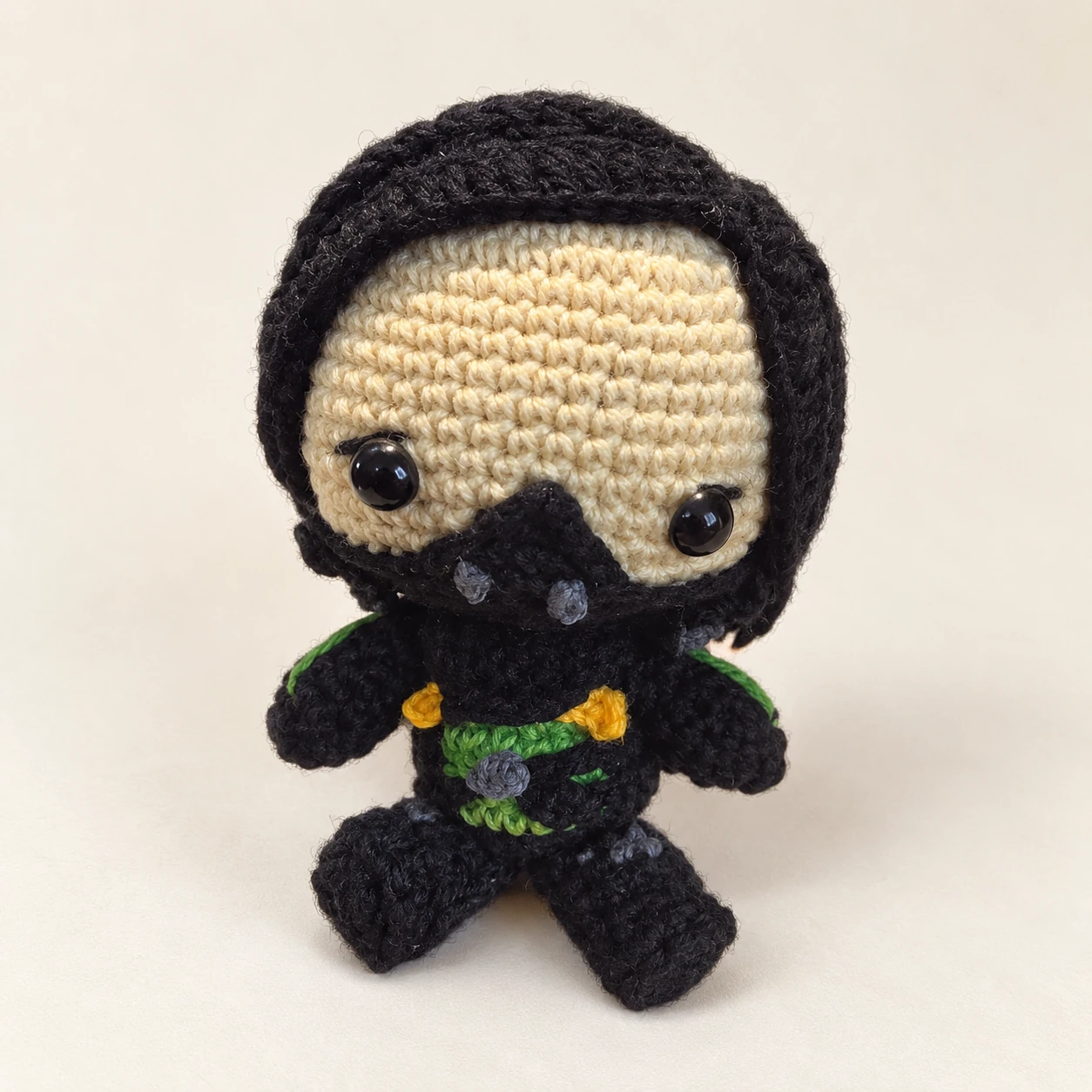 Viper crochet doll with black hair, a face mask and a black and green outfit